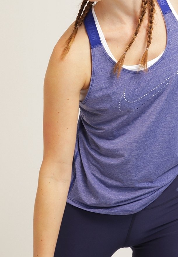 Fioletowy sportowy tank top z jasnoniebieską lamówką, z połyskującym logo Nike wykonanym z małych koralików, wykonany z oddychającego materiału.