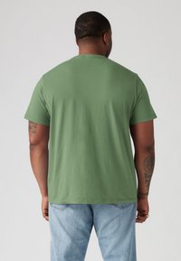 Olijfgroene katoenen t-shirt met een ronde hals en korte mouwen, voorzien van een comfortabele pasvorm en een gladde, zachte textuur.