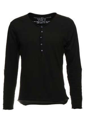 Czarna koszula z długim rękawem i dekoltem w kształcie litery V, posiada pięcioprzyciskowy zapięcie oraz lekko zaokrąglony dół. Miękka tkanina bez wzorów.