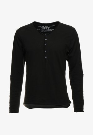 Czarna koszula z długim rękawem i dekoltem w kształcie litery V, posiada pięcioprzyciskowy zapięcie oraz lekko zaokrąglony dół. Miękka tkanina bez wzorów.