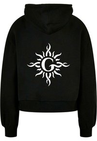 Fekete rövid fazonú kapucnis pulóver v-kivágással és hosszú ujjakkal. Középen található egy fehér napmotívum, amibe be van építve a "G" betű. Pamutkeverék.