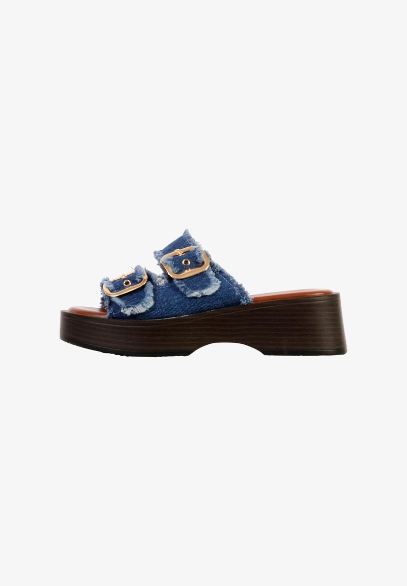 Sandale plateforme avec semelle marron foncé et brides en denim effilochées, chacune avec une boucle dorée, vue latérale sur fond blanc.