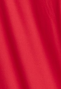 Czerwony materiał o gładkiej, matowej fakturze, z subtelnym połyskiem i lekkim spadaniem. Jednolity kolor bez widocznych wzorów lub deseni.