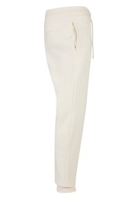 Pantalones de chándal beige con cintura ajustable, bolsillos laterales, diseño de pierna ajustada y puños elásticos. Material suave con textura lisa.