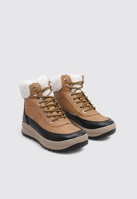 Braune Leder-Wanderschuhe mit einem weichen weißen Kragen, schwarzer Gummisohle und goldenen Ösen. Sie verfügen über ein Design aus gemischten Materialien für Langlebigkeit.