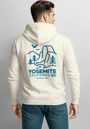 Cremefarbener Kapuzenpullover mit einem blauen Grafikdesign des Yosemite-Nationalparks, das Berge, Bäume und Wasser zeigt. Der Text beinhaltet "Yosemite Kalifornien USA."
