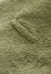 Weicher, strukturierter Stoff in einem gedeckten Olivgrün; enthält plüschige Fasern, die ein gemütliches, warmes Erscheinungsbild mit einem leichten Glanz erzeugen.