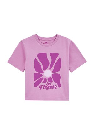 T-shirt en coton rose à manches courtes, avec un grand graphique d'une fleur violette et le texte "la vague" dans une police stylisée en bas.