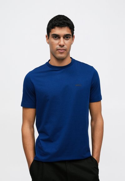T-shirt bleu à manches courtes en tissu doux, avec un col rond et un petit logo "BOSS" marron sur le côté gauche de la poitrine.