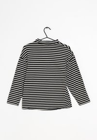 Top a maniche lunghe a righe bianche e nere con collo alto, realizzato in tessuto dalla superficie liscia, caratterizzato da una vestibilità morbida e fessure laterali.