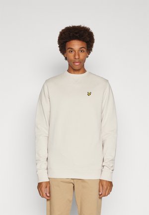Sweatshirt beige en coton, avec un col rond et des manches longues. Logo brodé jaune distinctif sur la poitrine gauche.