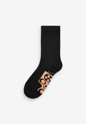 Schwarze Socken mit einem orangefarbenen und bunten Leopardenmuster. Hergestellt aus einem weichen, elastischen Material mit einem gerippten Bündchen.