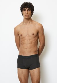 Boxer shorts en coton noir à coupe ajustée, avec une taille logo, une texture lisse et un design de poche frontale sculptée.
