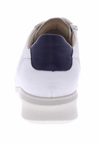 White leather sneaker with a navy blue heel cap, rounded toe, and a light grey sole. Features clean lines and a zip closure on the side.