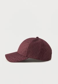 Casquette de baseball violet foncé avec un motif géométrique texturé subtil, visière incurvée et œillets de ventilation cousus sur un fond clair.