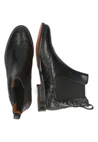 Bottes Chelsea en cuir noir avec motif texturé, panneaux latéraux élastiques, languettes de traction et semelles marron, présentées en vues de dessus et de côté.