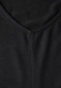 Svart bomullsblandat tyg med en slät textur, V-ringning och subtila sömnadsdetaljer. Inga synliga mönster eller accenter.