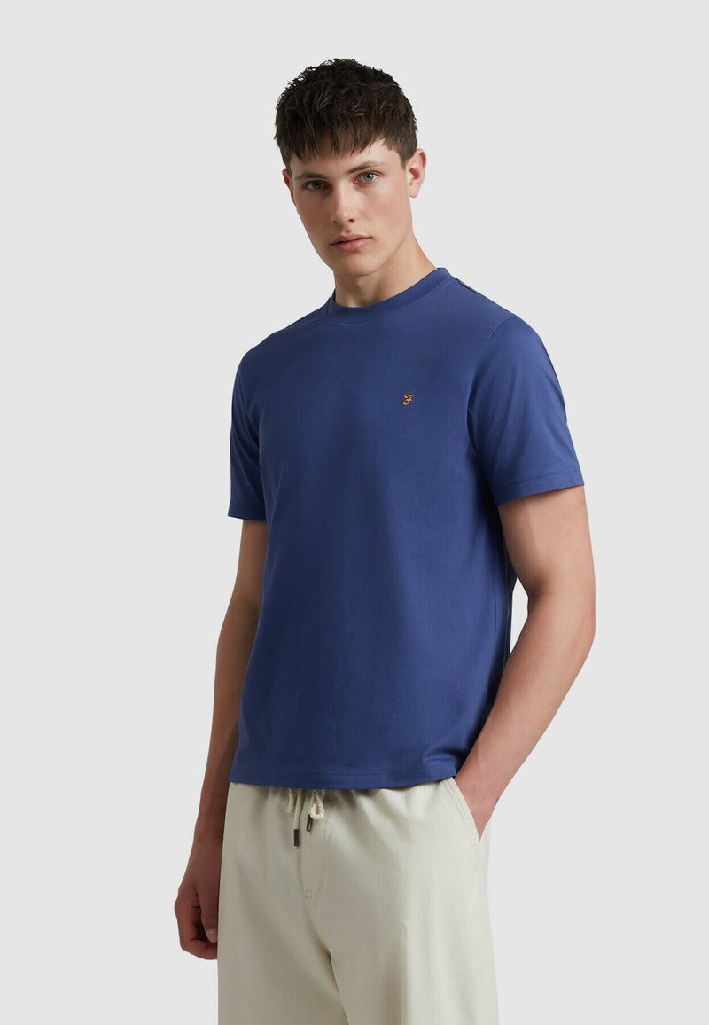 T-shirt in cotone blu navy con colletto rotondo e maniche corte. Presenta un piccolo logo arancione ricamato sul lato sinistro del petto.