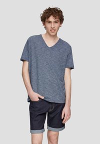 Niebieska koszulka z krótkim rękawem i dekoltem w serek, wykonana z heathered materiału, w połączeniu z ciemnoniebieskimi szortami dżinsowymi podwiniętymi na końcach. Prosty wzór z luźnym krojem.