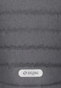 Grå puffv�äst med vertikal quiltad textur, med en gummibelagd logotypetikett märkt "ZIGZAG" längst ner.