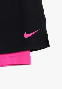 Mustat urheilushortsit, joissa on vaaleanpunainen Nike-logo, ja vaaleanpunainen vyötärönauha, joka erottuu. Kangas on sileä ja urheilullinen muotoilu.