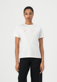 White cotton t-shirt featuring pink embroidered "Hugo" logo at the chest, short sleeves, and a crew neck design.