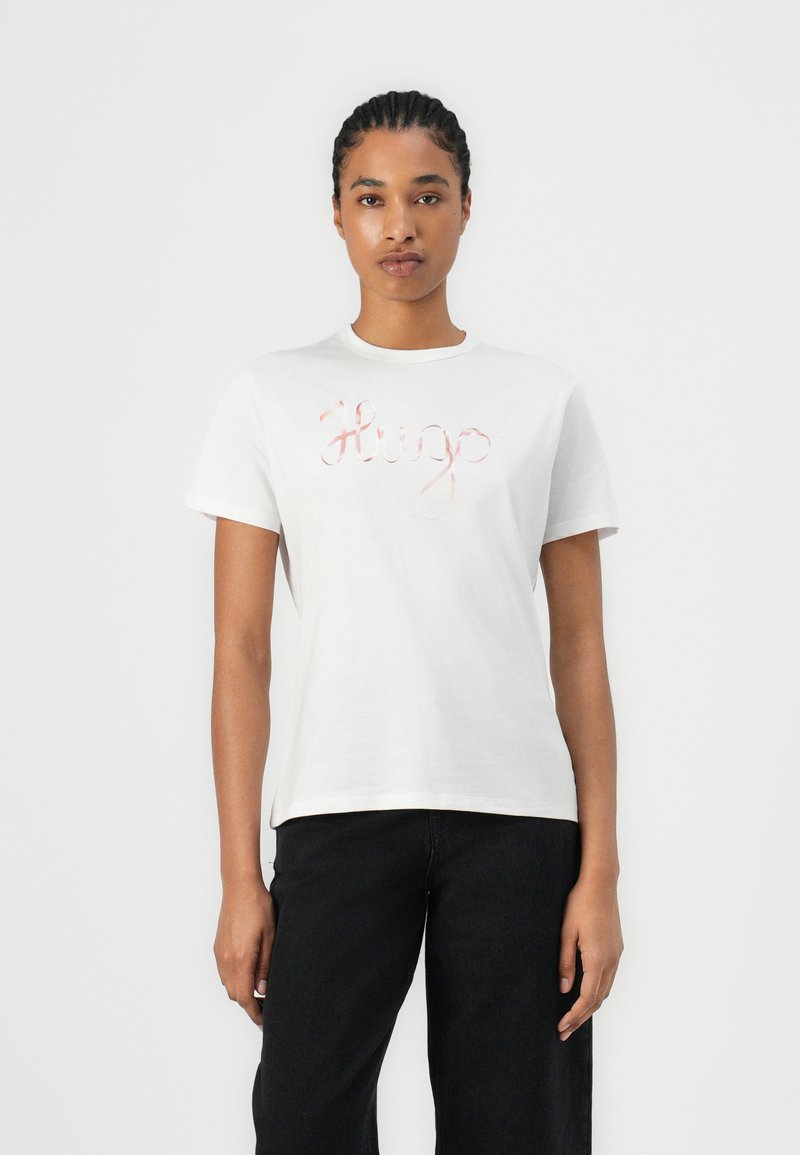 Hvit bomull t-skjorte med rosa brodert "Hugo" logo på brystet, korte ermer og rund hals.
