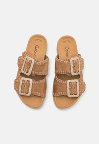 Ruskosuede slide sandaalit, joissa on kaksi leveää hihnaa, joissa on vaaleansävyiset neliömäiset soljet ja kontrastoiva tikkaus. Pehmustettu pohja, jossa logo.