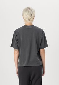 Gray cotton t-shirt with a relaxed fit, short sleeves, and a crew neck. Features a slightly distressed hem and casual design.