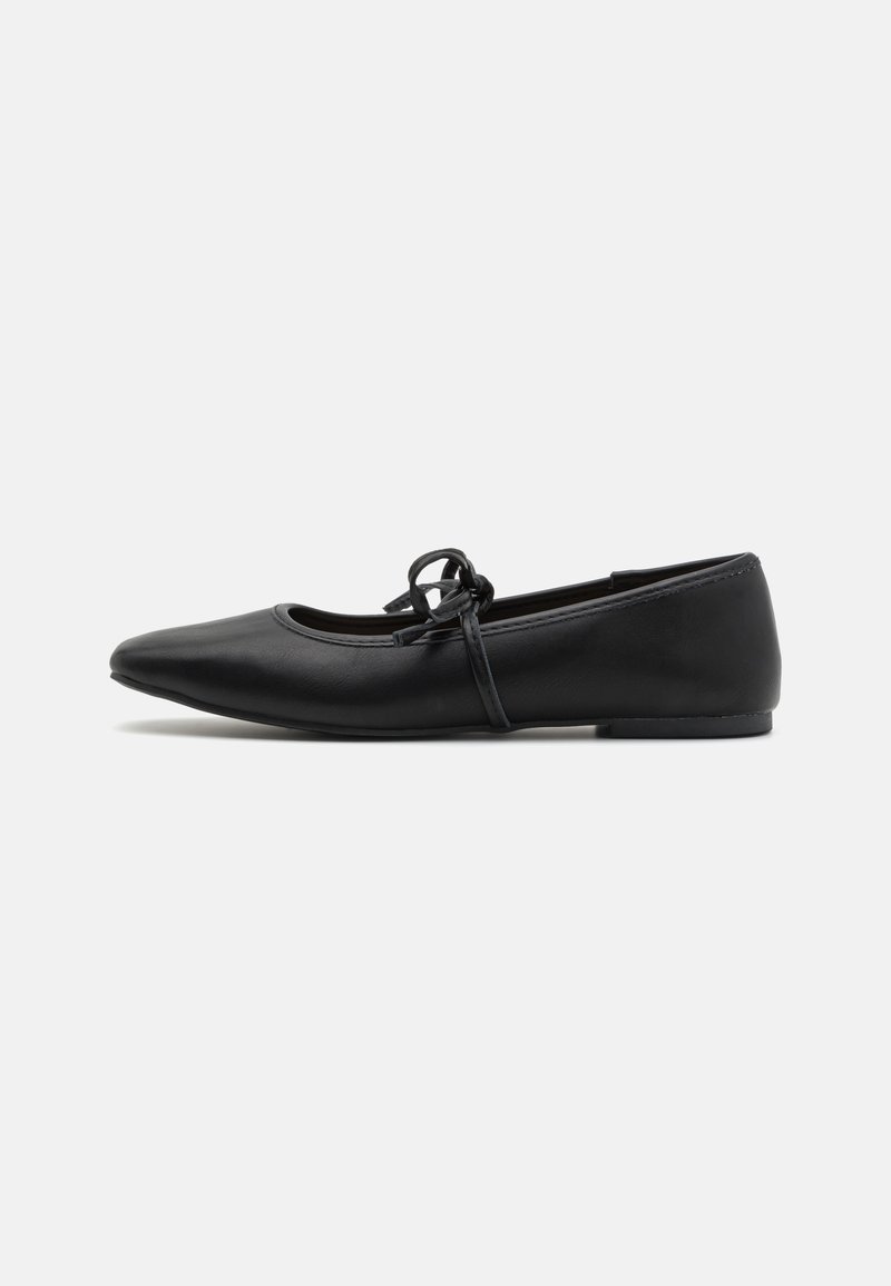 Black leather ballet flats with a rounded toe, thin ankle strap, and a decorative bow on the vamp. Flat sole with minimal texture.