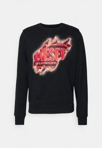 Sudadera negra con un gráfico destacado en rojo que dice "DIESEL" con un efecto de pintura en spray y desgastado. Puños y escote acanalados.