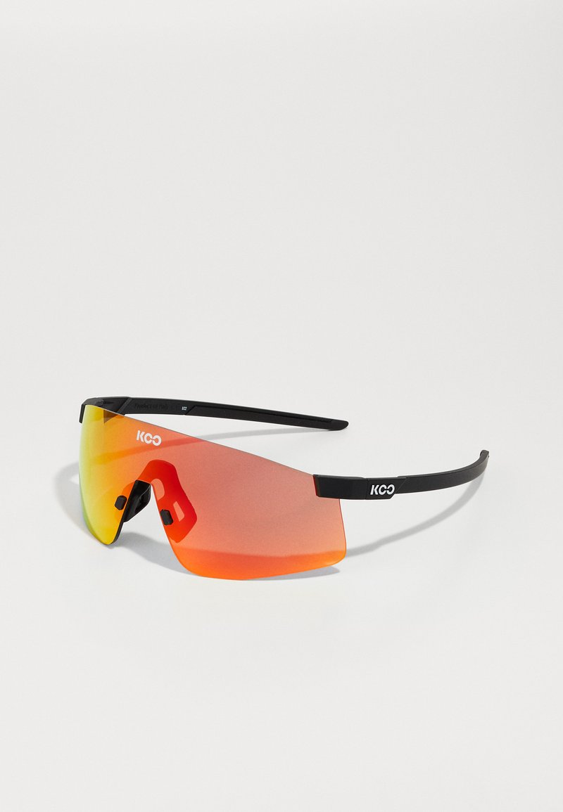 Óculos de sol desportivos com armação preta e lentes laranja grandes, apresentando um design envolvente e almofadas nasais ajustáveis para um ajuste seguro.