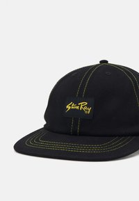 Black cap with yellow stitching and a rectangular logo patch. Features a curved brim and six-panel design with ventilation holes.