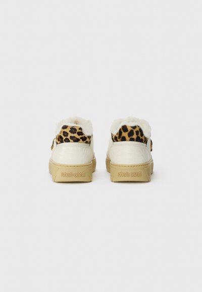 White sneakers with leopard-print heel accents, faux fur lining, and rubber soles. Features embossed brand logo on the back.
