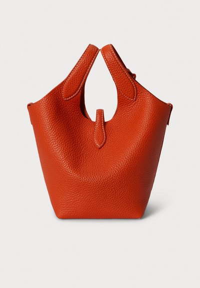 Oranžna torbica iz teksturiranega usnja z edinstveno zaobljeno obliko, dvema zgornjima ročajema in osrednjim patentnim detajlom. Šivi poudarjajo njen dizajn.