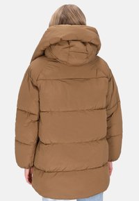 Een bruine pufferjack met een grote capuchon, voorzien van horizontaal doorgestikte delen en een relaxte pasvorm. Gemaakt van glad, lichtgewicht materiaal.