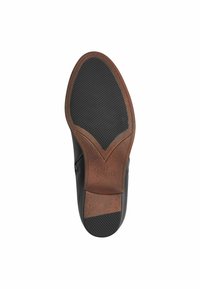 Suela de zapato negra con una base de cuero marrón, que presenta un agarre de goma negra texturizada y un diseño distintivo en forma de V. Talla marcada como 37.