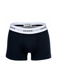 Dark navy men's boxer shorts made of soft cotton, featuring a white elastic waistband with repeating "LACOSTE" logo.