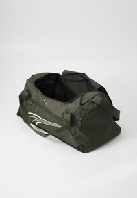 Olijfgroene sporttas van duurzaam materiaal, met een zwarte bodem, een ritsvak en een lichtgroen golfontwerp aan de zijkant.