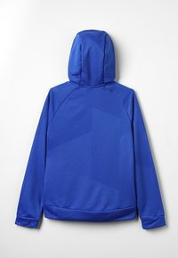 Giacca con cappuccio blu caratterizzata da un motivo geometrico testurizzato, polsini a coste e una finitura liscia. La vista posteriore mostra linee pulite e semplici.