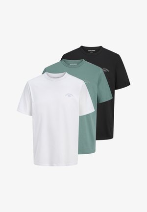 Trois t-shirts unis à col rond en blanc, vert et noir avec de petits logos sur la poitrine, disposés en couches du devant vers l'arrière.