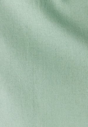 Světlé zelené látka s hladkou texturou, zobrazující jemný vzor tkaní. Materiál působí měkce a lehce, bez viditelných vzorů nebo akcentů.