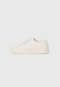 White canvas sneakers with a low profile, round toe, and textured rubber sole. Features simple lacing and minimal branding on the side.