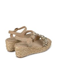 Beige Wedgesandalen mit geflochtenen Jutesohlen, Knöchelriemen und dekorativen Strassverzierungen an der Vorderseite. Weiches Wildledergefühl.