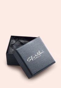 Svart texturerad smyckeslåda med locket något öppet, med vit text som säger "Sofia Milani Jewels." Innehåller svart silkespapper inuti.