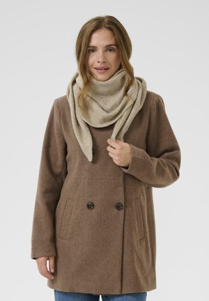 Manteau en laine marron avec double boutonnage et poches latérales, associé à une écharpe beige clair, présenté sur un fond uni.