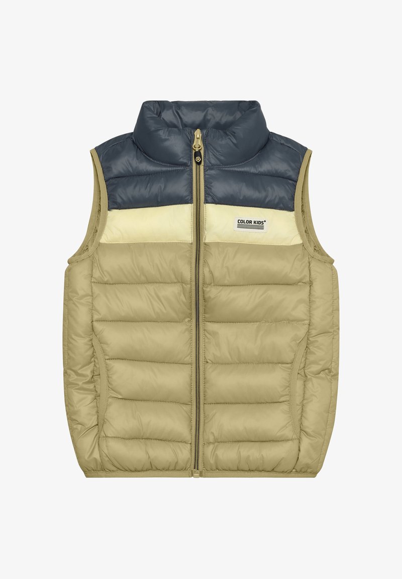 Gewatteerd vest in beige en marineblauw, met een hoge kraag en een crèmekleurig paneel, een rits aan de voorkant en zijzakken. Het materiaal is glad met een doorgestikte textuur.