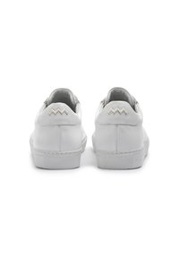 Baskets blanches en cuir avec une finition lisse, semelle plate en caoutchouc et accent en zigzag sur le talon. Design minimaliste sans logos visibles.