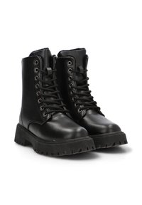 Botas de cuero negro hasta el tobillo con una suela de goma gruesa, cordones en la parte frontal y ojales metálicos. Presentan una textura suave y un cuello acolchado.