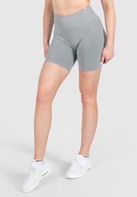 Grijze sportshorts met een hoge tailleband, voorzien van een gladde textuur en een aansluitend ontwerp, gecombineerd met witte sneakers.